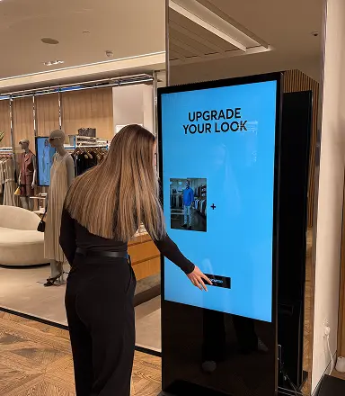 Customer interacting with the Upgrade Your Look touchscreen kiosk