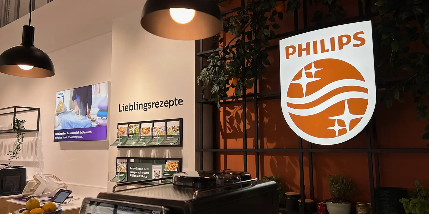 Illuminated Philips logo above a Lieblingsrezepte recipe display and NutriU app kiosk