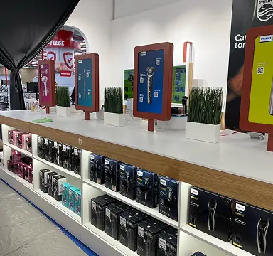Interactive kiosks on a retail shelf alongside personal care products