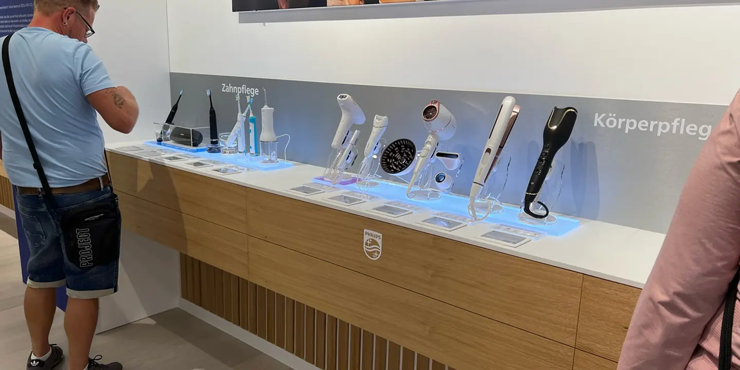 Customer exploring the Zahnpflege and Körperpflege product display wall