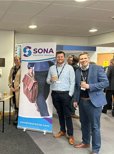 Sona Insurance Solutions team at the exhibition with a roll-up banner