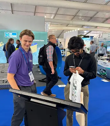 Sona team member engaging a visitor at the football kiosk