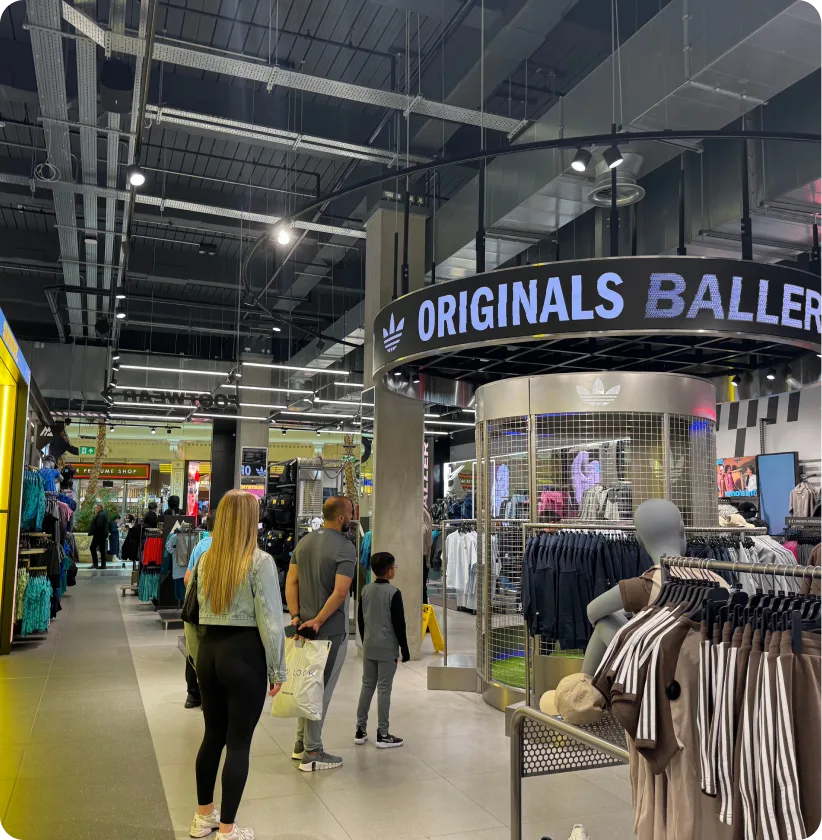 Shoppers walking past the physical game cage inside a retail store
